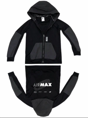 Svart airmax hoodie - Snygg svart hoodie från Nike med grå detaljer på ärmar, fickor och huva. Dragkedja framtill, två stora fickor och trycket 'AIR MAX' i vitt på ryggen. Perfekt för en sportig och avslappnad stil.
