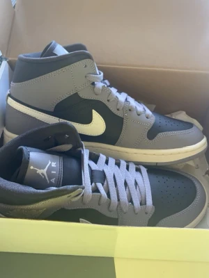 Nike Air Jordan 1 Mid lila blå - Snygga Nike Air Jordan 1 Mid sneakers i lila och blå färg med vita detaljer.