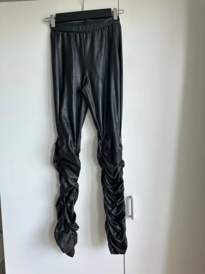 Leggins i skinnimitation och rynkdetaljer - Snygga leggins i skinnimitation och rynkdetaljer, mycket sparsamt använda