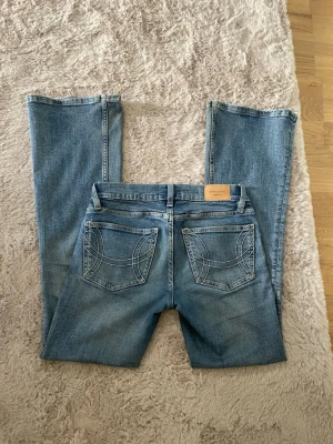 Ljusblå bootcut jeans med broderade fickor - Säljer ett par ljusblå bootcut jeans med snygga broderade detaljer på. De är i perfekt skick               Innerbens mått: 76 cm ytterbens mått: 97 cm midjemått: 38 cm. De är också stretchiga i tyget 