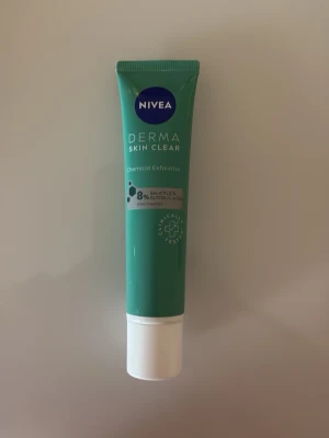 Nivea Derma Skin Clear Exfoliator - Nivea Derma Skin Clear Chemical Exfoliator med 8% salicylsyra och glykolsyra. Kommer i en grön tub med vit kork, perfekt för exfoliering av huden. Tuben rymmer 40 ml och är enkel att använda i din hudvårdsrutin. Endast testad 1 gång☺️