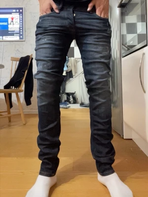  jack & jones Mörkblå slim fit jeans - Snygga mörkblå slim fit jeans med lätt slitna detaljer och klassisk femficksdesign. Jeansen har en något tvättad look och raka ben. Perfekta för en avslappnad och trendig stil. Materialet är denim i bomull.