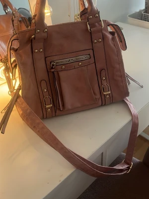Rosa petite bag med detaljer  - Fin rosa handväska med guldiga detaljer, använt få gånger och är köpt i en butik i Italien. Svår att få tag i. 