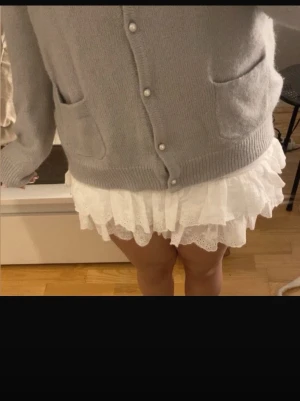 Mintgrön kofta med pärlknappar - Supersöt kofta med pärlknappar och två fickor framtill. Koftan har en mjuk och lite oversized passform, långa ärmar och ribbade muddar. Perfekt att slänga över en topp eller klänning för en chill och stylish look. OBS! Saknas en knapp. Men man tänker inte på det om man har de översta knapparna uppknäppta.