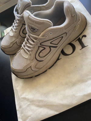 Gråa b30 - Säljer ett par gråa B30 sneakers med mesh och läderdetaljer. Skorna har en chunky sula och den ikoniska B30-loggan i svart på sidan. Klassisk snörning och bekväm innersula. Kommer med originalpåse och låda.