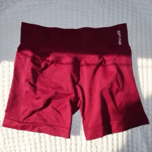 DFYNE Impact Shorts - DFYNE Impact Shorts 4.5                                                 DFYNE shorts i en röd/vinröd färg. Säljes då den inte kommer till användning. Inga fläckar eller skador, nyskick! Nypris - 563,99kr