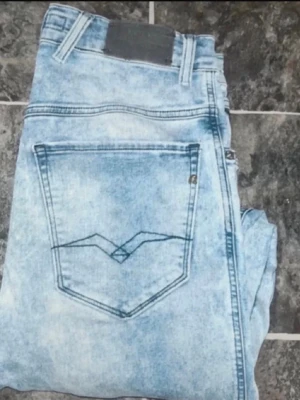 Replay jeans  - Säljer ett par Replay jeans i ljusblå tvätt med slim passform. Klassisk femficksmodell med snygga detaljer på bakfickorna. .längd 110, midja 39cm. Ifall det inte finns någon bild i annonsen där jag bär plagget så är det för att jag ej kan ha storleken heller passformen, så kolla måtten för storlek och googla på modellnamnet för passform 😉jeansen HAR INGEN LÄNGD STORLEK MEN BEDÖMS TILL L34 (r30)