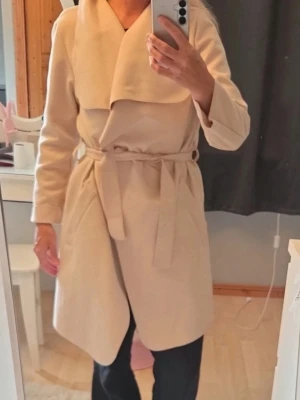 Beige omlottkappa med bälte - Står ingen storlek eller märke. Men jag har S och den passar. Sträv i materialet.