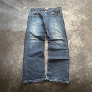 Mörkblå Wrangler distressed vintagejeans för herrar i storlek W31 L31 - Mörkblå Wrangler Distressed-vintagejeans. Sliten look och bekväm passform. Tunnare denim.  Mått 📏 Midja: 42 cm Benslut: 20 cm Lår: 31 cm Totallängd: 101 cm Måtten finns även på bilderna  Skickas inom ett dygn Spara på priset och frakten genom att sätta ihop ett paket Mer information finns på min profil  13-118