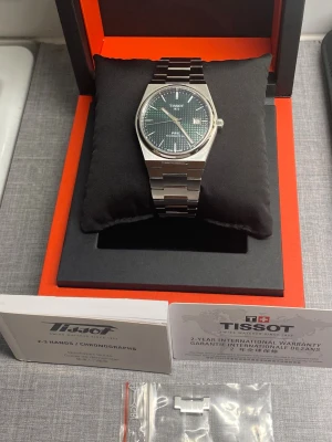 Tissot prx Powermatic 80 grön urtavla full set automatisk - Säljer nu min mycket fina Tissot PRX Powermatic 80 i den populära 40 mm-versionen med grön urtavla.  Klockan fungerar utmärkt med det pålitliga powermatic 80 urverket. Den är i väldigt gott använt skick med normala mindre bruksspår som inte går att undvika vid vardagligt bruk. Klockan levereras full set med alla dess tillbehör som bilderna i annonsen visar.  Nypris 9100kr.                                                      Jag har gott om referenser och tidigare affärer, hör av er vid frågor!