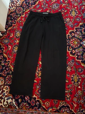 Svarta mjukisbyxor Abercrombie & Fitch - Säljer ett par svarta mjukisbyxor från Abercrombie & Fitch i storlek M. Byxorna har raka ben, dragsko i midjan och sidofickor. Perfekta för chill dagar eller när du vill vara extra bekväm. Materialet är mjukt och skönt.