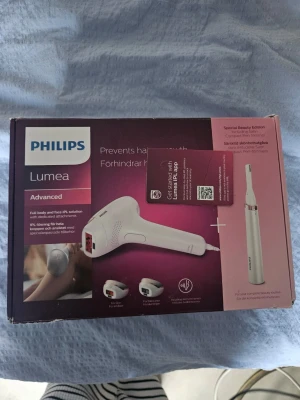 Philips Lumea IPL hårborttagningskit - Philips Lumea Advanced IPL hårborttagningskit för kropp och ansikte. Inkluderar flera munstycken och en precisionstrimmer. Vit och rosa design, levereras i originalförpackning. Perfekt för långvarig hårborttagning hemma.