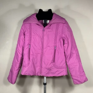 GAS Rosa pufferjacka med dragkedja - Säljer en snygg rosa pufferjacka med dragkedja framtill och två praktiska fickor med dragkedja. Jackan har en hög krage och quiltade sömmar som ger en cool look. Perfekt för kalla dagar när du vill hålla dig varm och samtidigt se trendig ut.0239