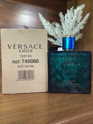 Versace Eros Eau de Toilette 100 ml - Versace Eros Eau de Toilette i en snygg, turkosblå glasflaska med guld- och blått lock. Flaskan har ett elegant Medusa-huvud i relief och geometriskt mönster. Doften är fräsch och maskulin, perfekt för dig som gillar exklusiva parfymer.