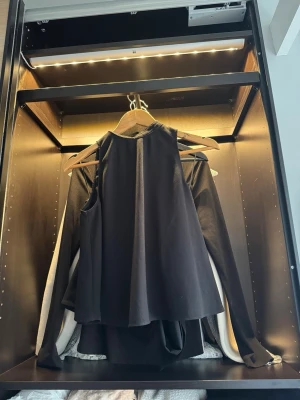 Svart ärmlös linnetopp - Säljer en svart, ärmlös linnetopp med rund halsringning och lös passform. Toppen har en enkel och stilren design som passar perfekt till många olika outfits. Materialet känns mjukt och följsamt mot huden.
