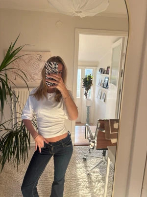 Vit croppad topp med knyt i ryggen - Säljer en vit croppad topp med korta ärmar och snygg knytning i ryggen. Toppen har en enkel och clean look, perfekt till jeans eller kjol. Storlek xxs, Nelly!!🤍