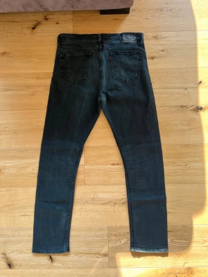 Vintage Levi’s 502 Regular Taper W34 L32 – Black Wash  - Säljer ett par Levi’s 502 Regular Taper i en stilren svart/grå wash. Jeansen är i mycket fint skick med minimal användning och utan hål eller större slitage. År:2012-2015
