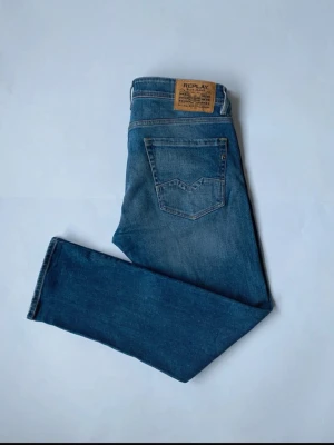 Replay jeans  - Säljer ett par klassiska blå jeans från Replay med raka ben och fem fickor. Jeansen har en snygg tvätt med lätt slitning och patch med Replay-logga bak i midjan. Perfekta till vardagslooken och passar till det mesta. Materialet är mjukt och bekvämt denim.