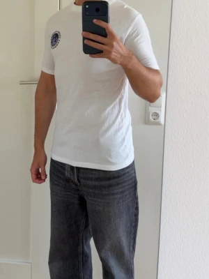 T-shirt  - Vit T-shirt med tryck fram och bak. Storlek S.