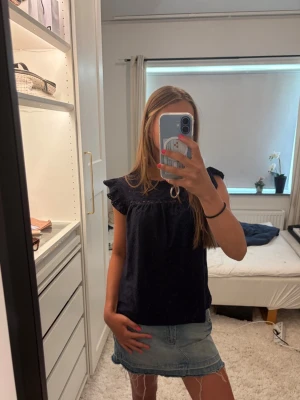 Mörkblå blus med volangärmar - Säljer en jättesöt mörkblå blus med volangdetaljer vid ärmarna och broderade hålmönster. Superfin topp att ha i sommar 💗💗