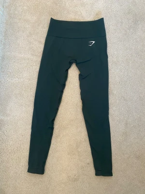 Träningstights  Gymshark - Säljer ett par gröna tights från Gymshark med hög midja och stretchigt material. Perfekta för träning!💪