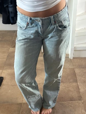 Ljusblå raka jeans med låg midja från Zara - Säljer ett par ljusblå jeans med rak passform och låg midja från Zara. Jeansen har klassiska fem fickor och bälteshällor. Perfekta för en avslappnad och trendig look. Materialet är denim i bomull. Använda fåtal gånger. De är uppsydda så de passar mig som är ca 162💕