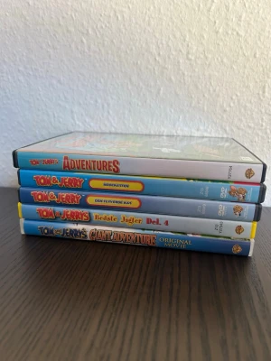 Tom & Jerry dvd paket - Detta paket innehåller fem Tom & Jerry DVD-filmer. Språk: Adventures: Svenska, Danska, Norska, Finska, Engelska, Polska, Portugisiska   Mode: Svenska, Danska, Norska, finska, Engelska   Flygande: Svenska, Danska, Norska, Finska, Engelska   Bedste: Svenska, Danska, Norska, Finska, Engelska   Giant: Engelska, Tyska, Franska, Italienska, Spanska   OBS!! skivorna är begagnade.  OBS! Bedste funkar bra tills sista 15 min, sedan inte längre.