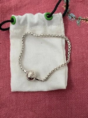 Silverarmband från Thomas Sabo - Snyggt armband i silverfärgat metall från Thomas Sabo. Armbandet har ett runt lås med ingraverad logotyp och dekorativ detalj. 