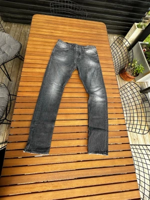 Grå dondup jeans - Säljer ett par grå jeans med slitningar och tvättade detaljer. Jeansen har rak passform, klassiska fem fickor och normal midja. Materialet är denim i bomull. Perfekta för en avslappnad och trendig look.