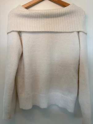 Offwhite stickad tröja från Lindex - Mysig offwhite stickad tröja från Lindex med bred ribbad krage som kan bäras off shoulder, i storlek 146/152.