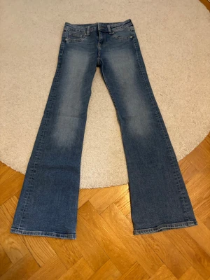 Blå bootcut jeans från H&M Divided - Säljer ett par blå bootcut jeans från H&M Divided i storlek 34. 