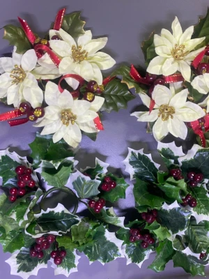 Dekorativa julblommor och blad - Säljer ett set med dekorativa julblommor och blad. Blommorna är vita med gulddetaljer och röda band, medan bladen är gröna med röda bär. Perfekta som accessoarer till julens outfits eller för att dekorera väskor och hår.