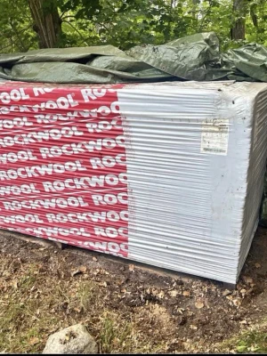 Rockwool Västkustskiva isolering - Ett stort paket Rockwool Västkustskiva isolering för ytterväggar med lufttät stomme. Skivorna är 30 mm tjocka, 2700 mm långa och 1200 mm breda. Förpackningen är vit och röd med tydlig märkning. Perfekt för byggprojekt och energieffektivisering.