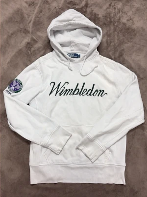 Vit Wimbledon hoodie Polo Ralph Lauren - Säljer en unik Ralph Lauren hoodie: officiell hoodie från Wimbledons 125-årsjubileum (2011). Väldigt sällsynt plagg! Storlek: S! Bra skick! Hör av dig vid frågor!