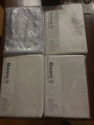 4 paketer med påslakan  - Fyra paket Basic sängkläder i vitt satinmaterial. Varje paket innehåller ett 2-delat bäddset med påslakan och örngott. Sängkläderna har en slät och mjuk yta som ger en lyxig känsla till sovrummet.
