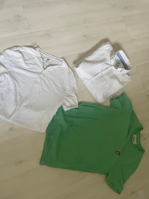 Lyle and ScottGrön t-shirt med broderad logga - Säljer en fräsch Lyle and Scott grön t-shirt med korta ärmar och en liten broderad gul logga på bröstet. T-shirten har en klassisk passform och är gjord i mjuk bomull, perfekt för en avslappnad stil.Zara vit skjorta och vit HM T-shirt 