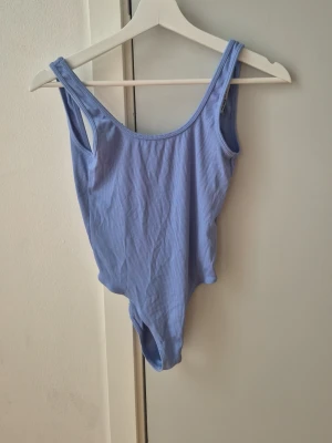 Ljusblå rygglöd body - Rygglös body i fint skick. Har varit en favorit här hemma.  Storlek S. 