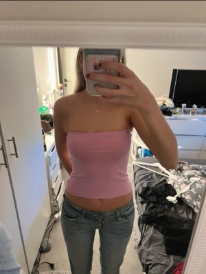 Ljusrosa bandeau tubtopp - Säljer en ljusrosa bandeau tubtopp i mjukt bomullsmaterial. Toppen är axelbandslös och croppad, perfekt till en kofta nu till hösten!