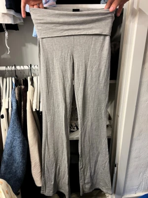 Grå mjuka yoga pants - Säljer ett par grå leggings med bootcut-modell och bred linning i midjan. 