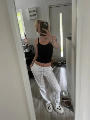 Vita linnebyxor - Säljer ett par vita linnebyxor med avslappnad passform och dragsko i midjan. Byxorna har raka ben och sidofickor, perfekta för en chill och stilren look. Materialet är lätt och luftigt, vilket gör dem sköna att bära under varma dagar. Dem är skrynkliga eftersom dem är nytvättade men det går att fixa med strykjärn 