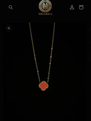 Guldhalsband med fyrklöverhänge - Snyggt halsband i guld med ett fyrklöverformat hänge i rödrosa nyans. Hänget har en pärlad kant som ger en exklusiv känsla. Perfekt accessoar för att lyfta din outfit med en färgklick och unik form.  Halsbandet är ifrån VELURICA pris går att diskutera hör av dig vid funderingar så fin halsband till en vän, flickvän eller mamma💞