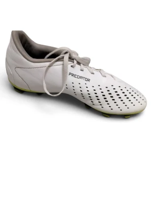 Vita Adidas Predator fotbollsskor - Säljer ett par vita Adidas Predator fotbollsskor med svarta detaljer och klassisk snörning. Skorna har mönstrad ovansida för bättre bollkontroll och dobbar för spel på gräs. Tillverkade i syntetmaterial och designade för att ge bra grepp och stabilitet på planen.