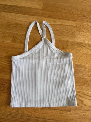 Topp Gina Tricot stl S - Ljusblå ribbad halterneck topp från Gina Tricot i storlek S.  Nyskick, endast testad.  Finns även i rosa på min profil.  