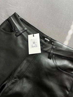 Svarta läderbyxor från Bik Bok - Säljer svarta bootcut läderbyxor från Bik Bok i storlek 36. Byxorna är i helt ny skick. 