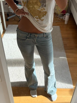 Ljusblå bootcut jeans med låg midja - Säljer ett par ljusblå jeans med bootcut-modell och låg midja. Stetchigt material, passar mig som är ca 168 för referens. Något smutsiga nertill, men troligtvis sådant som bara går bort i tvätten (inget som märks av tydligt)!