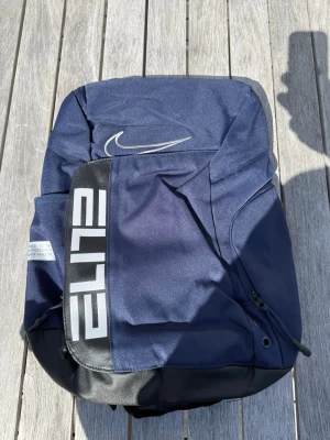 Nike Hoops Elite Ryggsäck – Mörkblå - Snygg och rymlig Nike Hoops Elite-ryggsäck i mörkblå design med silverdetaljer. Helt ny och aldrig använd. Perfekt nu när skolan börjar! Rymmer enkelt dator, böcker, ombyte och vattenflaska. Skickas snabbt 🚚💨 ✨ Rymliga fack och riktigt skön komfort för ryggen. 📩 Skicka gärna ett meddelande vid frågor eller prisförslag! 🛍️ Bundle-rabatt upp till 20%! 📦 Skickas samma eller nästa dag. 