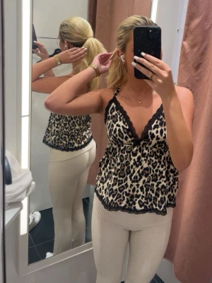 Leopardmönstrad linnetopp Gina Tricot - Säljer en leopardmönstrad linnetopp från Gina Tricot i storlek XS. Toppen har svarta spetsdetaljer längs urringningen och tunna axelband.