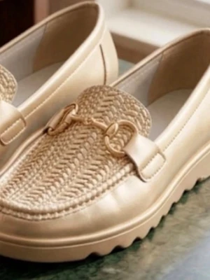 Beige loafers med flätad detalj - Snygga beige loafers med chunky sula och flätad ovandel i naturmaterial. Skorna har guldfärgad metallspänne framtill och en modern, bekväm design. Perfekta för dig som vill ha en stilren men trendig look.