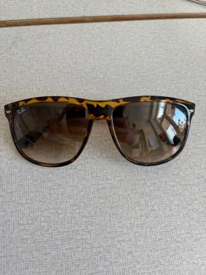 Ray-Ban boyfreind  leopard solglasögon - Snygga Ray-Ban boyfriend  solglasögon med leopardmönstrad båge i brunt och gult. Klassisk form med mörka glas som ger cool retrovibe. Perfekta för soliga dagar och en trendig look.