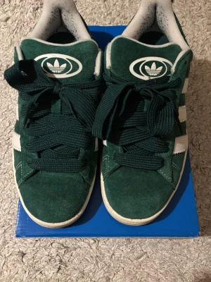 Gröna Adidas campus  - Säljer ett par gröna Adidas campus. Aldrig använda bara testade en gång inne så helt nya. Dom är tyvärr för stora för mig. Det är stl 40 & en tredje del. Kan tänka mig att gå ner i pris kom med rymliga prisförslag. Extra skosnören fins med också. 